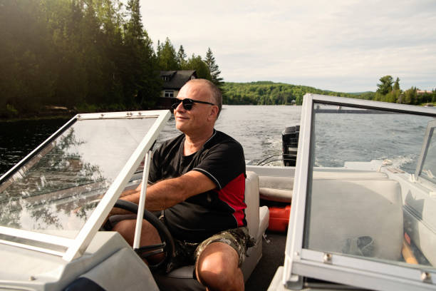 istock 50 + man driving small boat on a lake. 1255993204
