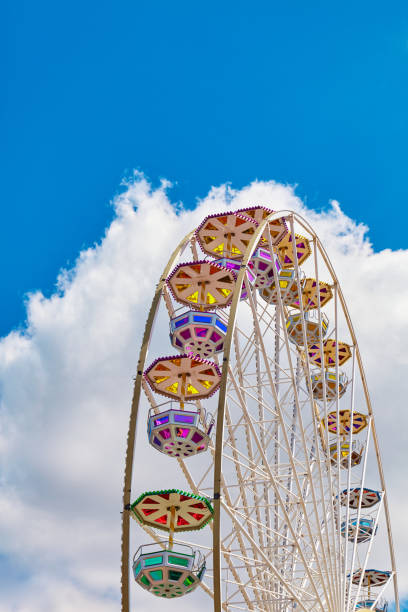 istock Ferris wheel on a sunny day with blue sky and cloud in background. 1255994483
