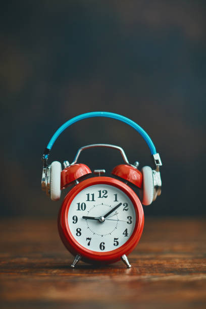 istock Alarm clock wearing headphones 1255997810