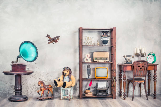 antiques still life with old gramophone, teddy bear, rocking horse and collection of outdated media, news makers and writers devices front concrete wall background. vintage style filtered photo - typewriter retro revival old fashioned the media imagens e fotografias de stock