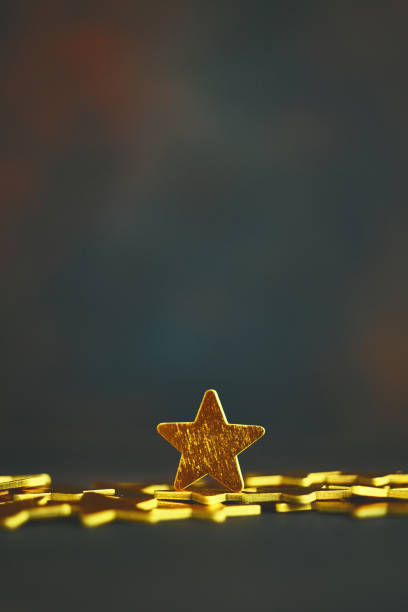 istock Shiny gold stars against dark background 1255998647