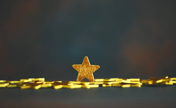 istock Shiny gold stars against dark background 1255998653
