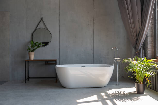 istock Modern minimalistic dark gray loft style studio apartment interior design. kitchen, sitting area, workplace, shower and bath. bright sun rays inside. 1256000843