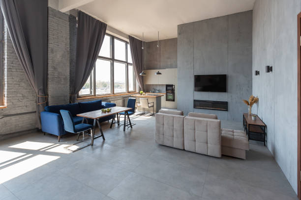 istock Modern minimalistic dark gray loft style studio apartment interior design. kitchen, sitting area, workplace, shower and bath. bright sun rays inside. 1256000853