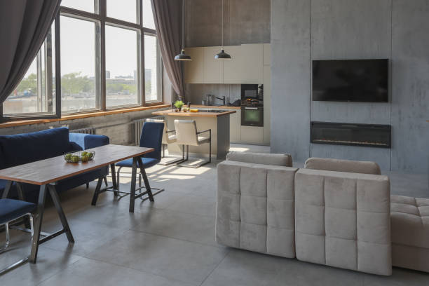 istock Modern minimalistic dark gray loft style studio apartment interior design. kitchen, sitting area, workplace, shower and bath. bright sun rays inside. 1256000896