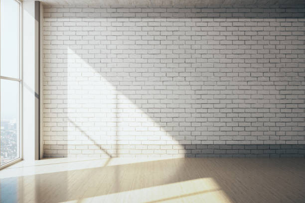 istock Modern gray gallery interior with empty brick wall, city view and daylight. 1256001937