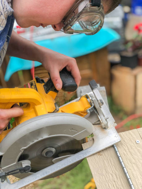 istock Carpenter Woman using an electric saw 1256002157