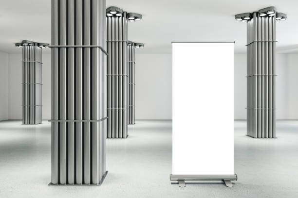 istock Minimalistic gallery interior with silver pipe columns and blank vertical poster. 1256002918