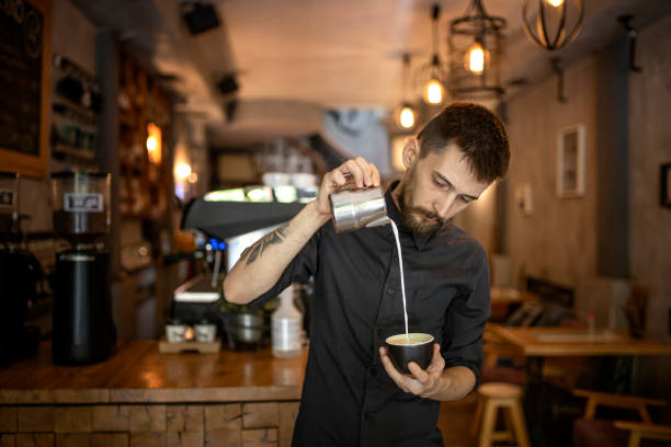 Barista is making coffee with milk