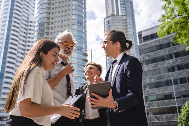 istock Young businessman showing business strategy plan to cheerful colleagues after work 1256005049