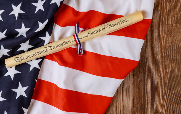 istock Parchment roll document with US flag on wooden background. 1256013419