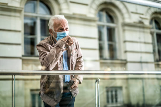 istock Senior man waiting on station and coughing. 1256014130