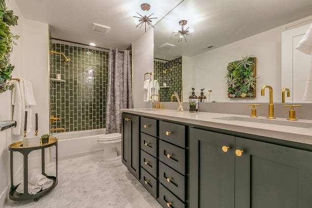 Green tile gives beauty and unique charm to this basement bathroom Green is the theme in this beautiful bathroom with brass faucets and fixtures bathroom stock pictures, royalty-free photos & images