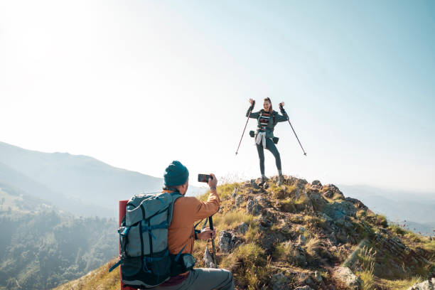 istock Young couple taking pictures while out hiking 1256022239