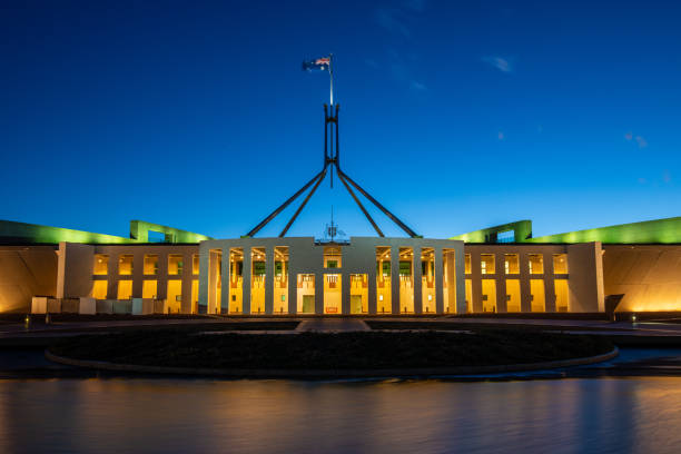 new parliament house, canberra, act, australia con bandiera australiana che sventola al crepuscolo - csi foto e immagini stock