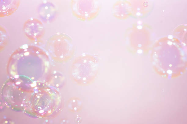 istock Beautiful rainbow soap bubbles float on pink background. Abstract bubble blur background. 1256024742