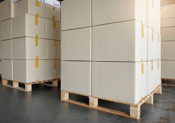 istock Stack of cardboard boxes on wooden pallets. package box, packaging. Manufactiring warehouse cargo shipment boxes. Logistics and transportation. 1256024744