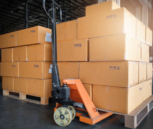 istock Stack of shipment boxes with hand pallet truck. Cargo export & Shipping warehouse, Logistics and transportation. 1256024746