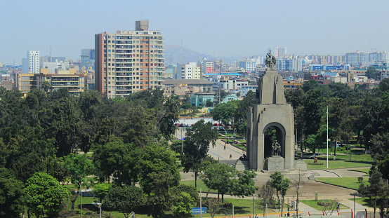 Aerial view from rooftop of the city of Lima (capital of Peru), with a huge park on first shot and lots of residential buildings, commercial towers of many sizes