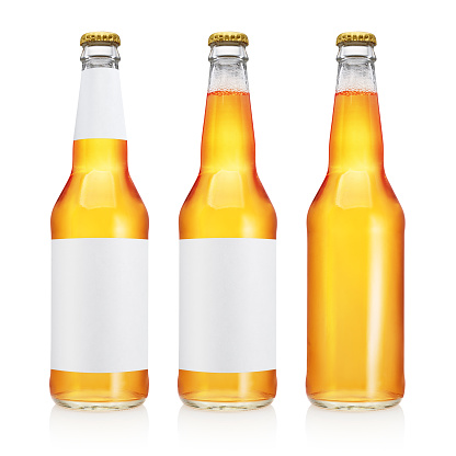 Three beer bottles with long neck and blank label, yellow color, isolated on white background.
