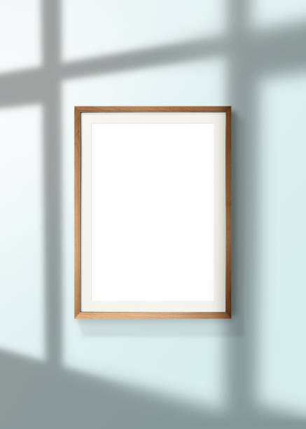 istock vertical poster wooden frame mock up on wall and window shadow with clipping path. 1256034820