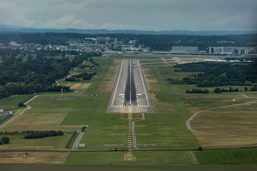 Runway view from the cockpit while landing at a large airport.