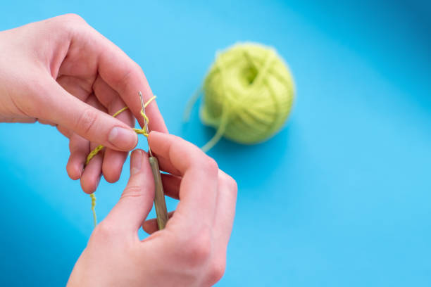 istock Crocheted hands with cotton and crochet on a light background, selective focus, with copy space, handmade 1256041898