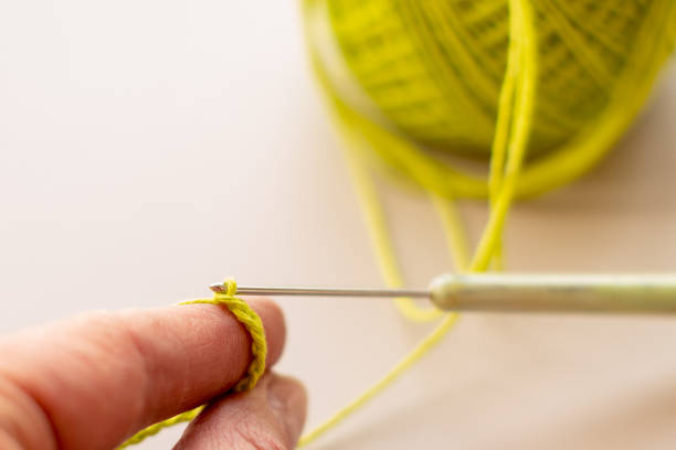 istock crocheted hands with cotton and crochet on a light background, selective focus, with copy space, hobby 1256041918