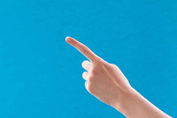 istock Caucasian white female hand with finger pointing, on a blue background, copy space 1256041936