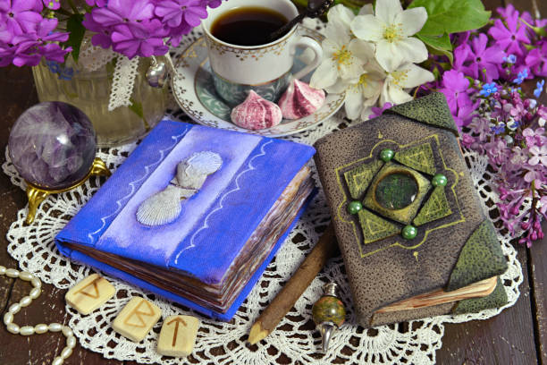 istock Decorated book and diary with cup of tea and flowers on green witch table. 1256042115