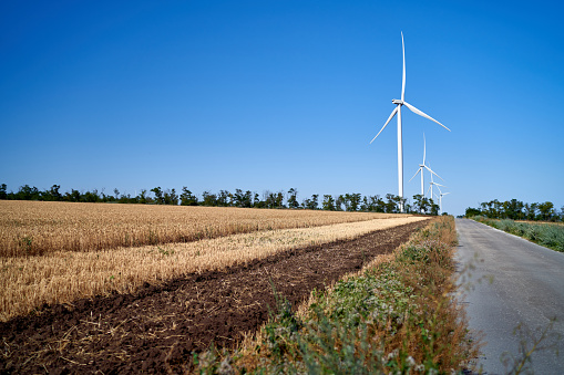 wind generators stand in a field outside the city