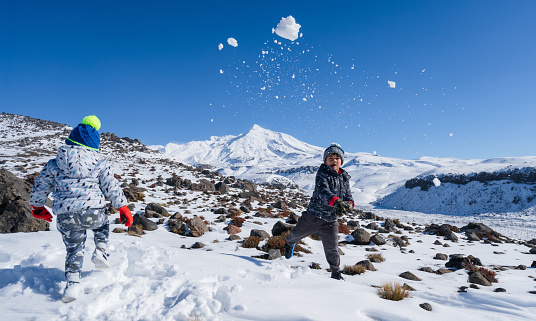 Kids enjoying weekend activities in snow heading towards Mt Ruapehu, National Park, New Zealand.