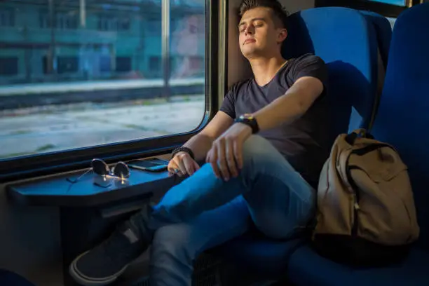 Photo of Young Man Sleeping In Train