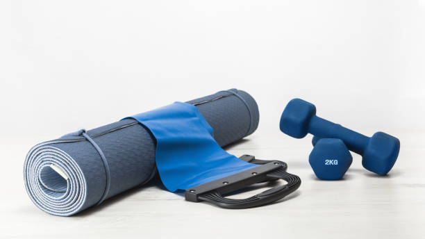 Rolled yoga mat and exercise resistance band and dumbbells