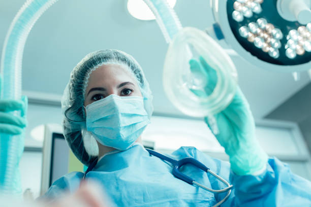 anestesiólogo experimentado preparando a su paciente para la cirugía - anestesista fotografías e imágenes de stock