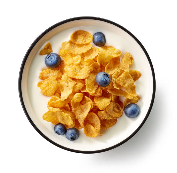 bowl of cornflakes and milk bowl of cornflakes and milk decorated with blueberries isolated on white background, top view corn flakes stock pictures, royalty-free photos & images