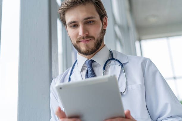 istock male medical doctor using tablet computer in hospital. 1256053784
