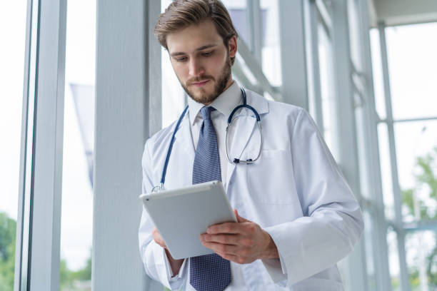 istock male medical doctor using tablet computer in hospital. 1256053785