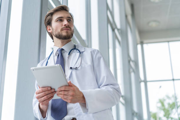male medical doctor using tablet computer in hospital.