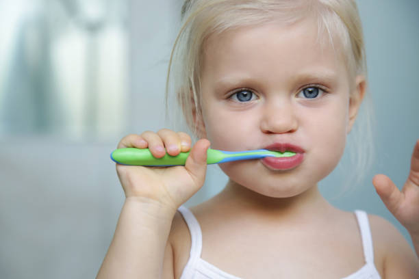 adorable niña de 3 años cepillando sus dientes en el baño. - child human teeth brushing teeth dental hygiene fotografías e imágenes de stock