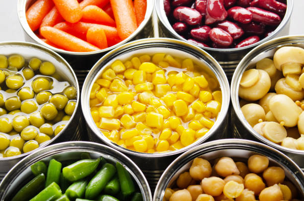 istock Canned vegetables in opened tin cans on kitchen table. Non-perishable long shelf life foods background 1256055275