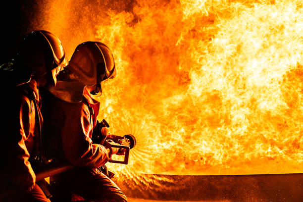 istock Firefighters use twirl water fog spraying down fire flame. 1256059257