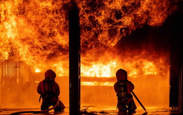 istock Firefighters use water fog spraying down fire flame in building. 1256059362