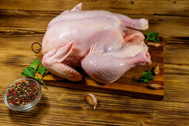 istock Raw whole chicken with spices on a wooden table 1256062704