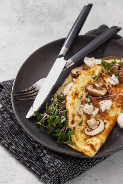 istock Omelette stuffed with mushroom, mozzarella cheese and microgreens for breakfast. Home kitchen. 1256064302