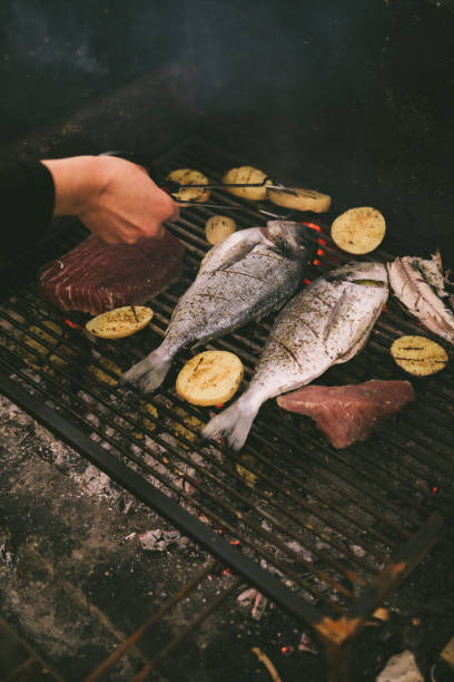 istock cooking fish and potatoes on grill 1256064320