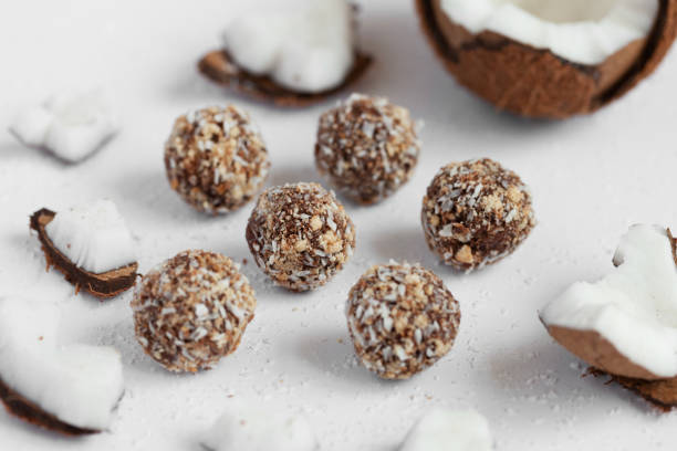 istock Coconut sweets with chocolate on a light wooden background. Natural sweets without sugar. 1256067143
