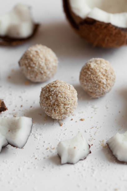 istock Coconut sweets with chocolate on a light wooden background. Natural sweets without sugar. 1256067146