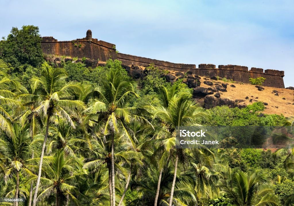 Chapora Fort above the Vagator Beach in Goa, India Goa, India, December 6, 2015: View of the Chapora Fort above the Vagator Beach. The site was the location of a fort built by Muslim ruler Adil Shah called Shahpura, whose name the Portuguese altered to Chapora. Goa is former Portugese colony. Fort Stock Photo