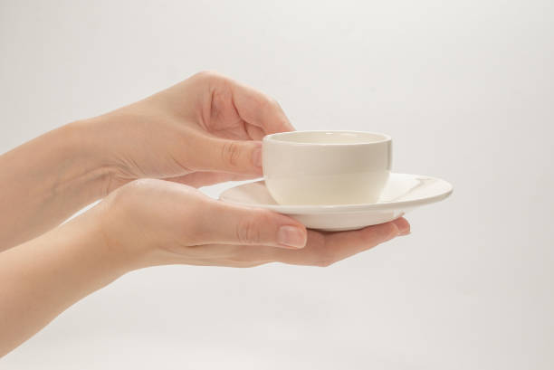 istock Empty coffee cup in woman hand isolated on white. 1256068892